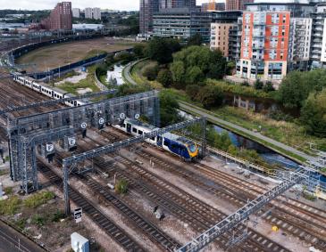 Aerial view of passenger train, tracks, and overhead line equipment