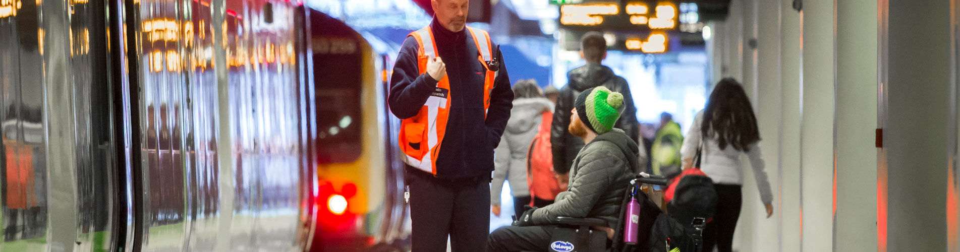 Wheelchair user being assisted by a member of staff at a railway station