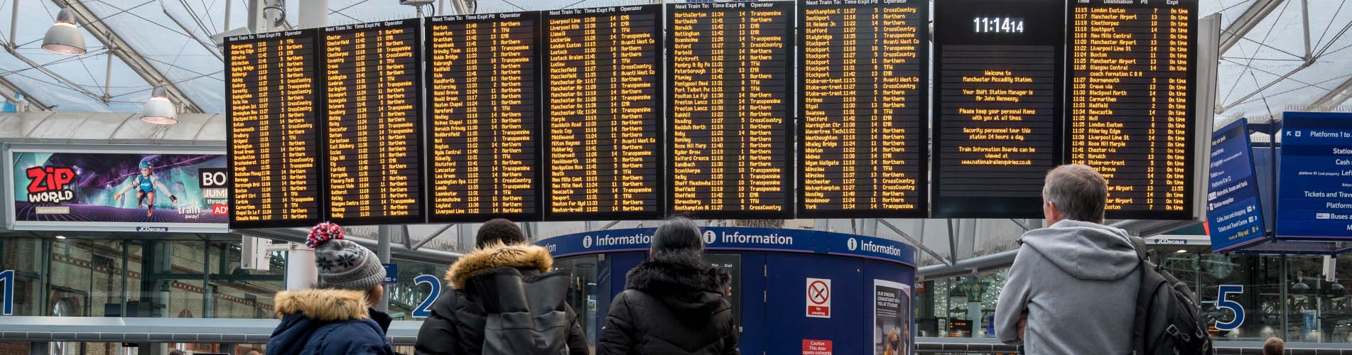 Passengers checking an information board at Manchester Piccadilly station