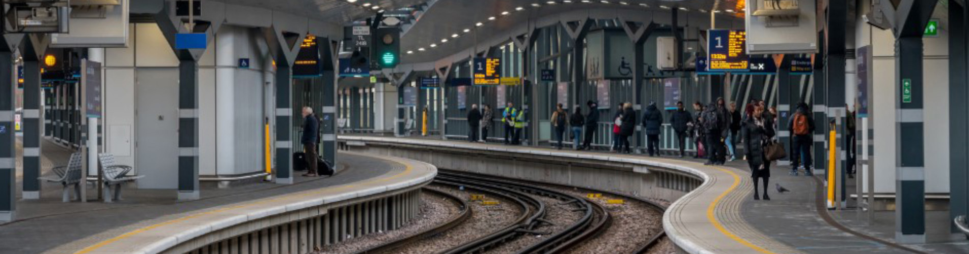 Passengers waiting for the next train on a train station platform.