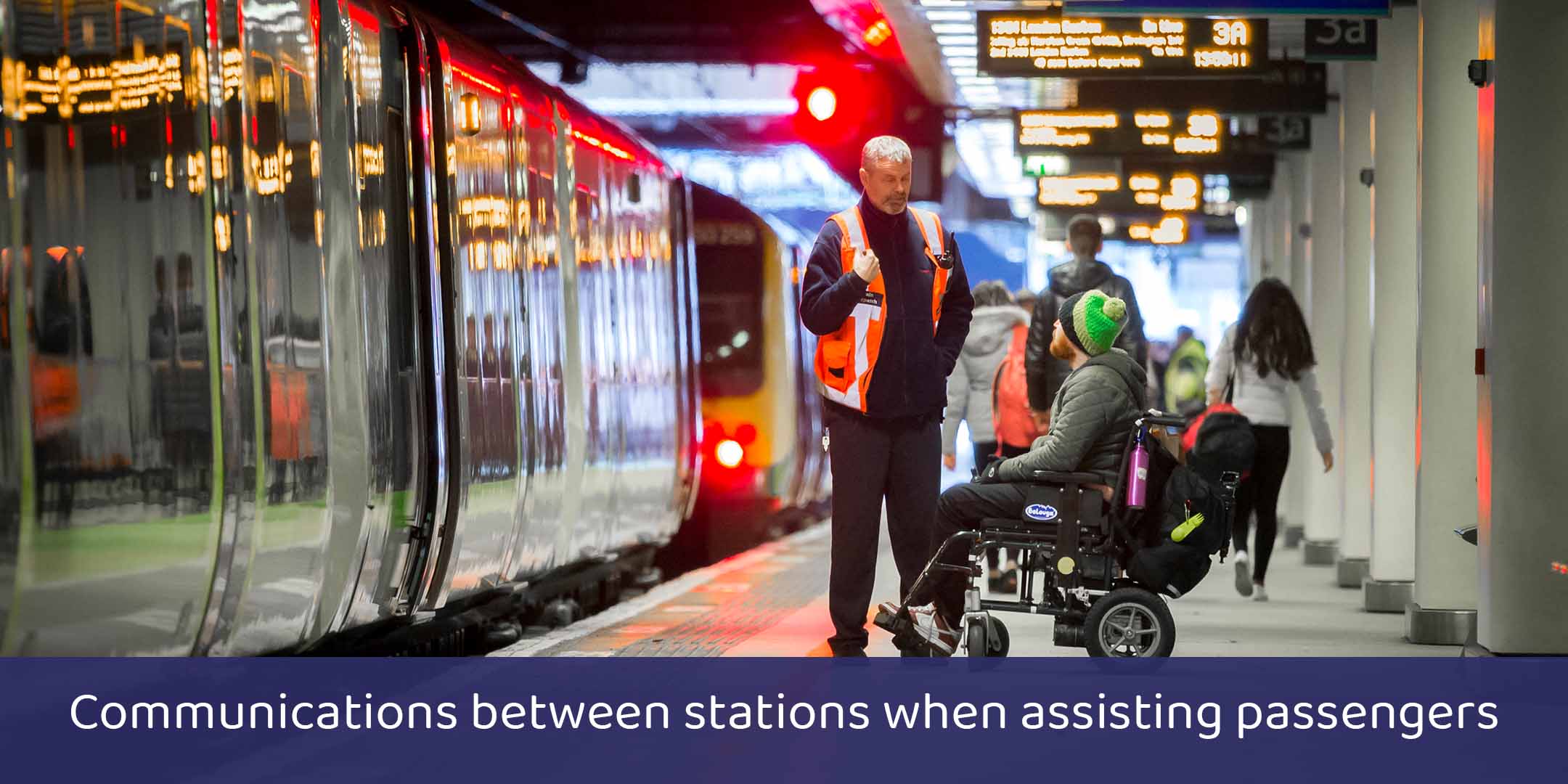 Wheelchair user being assisted by a member of staff on a railway station platform