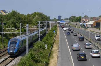 Railway track with train beside a road