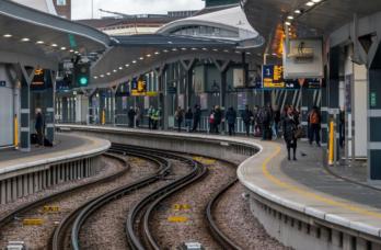 Passengers waiting for the next train at a station platform.