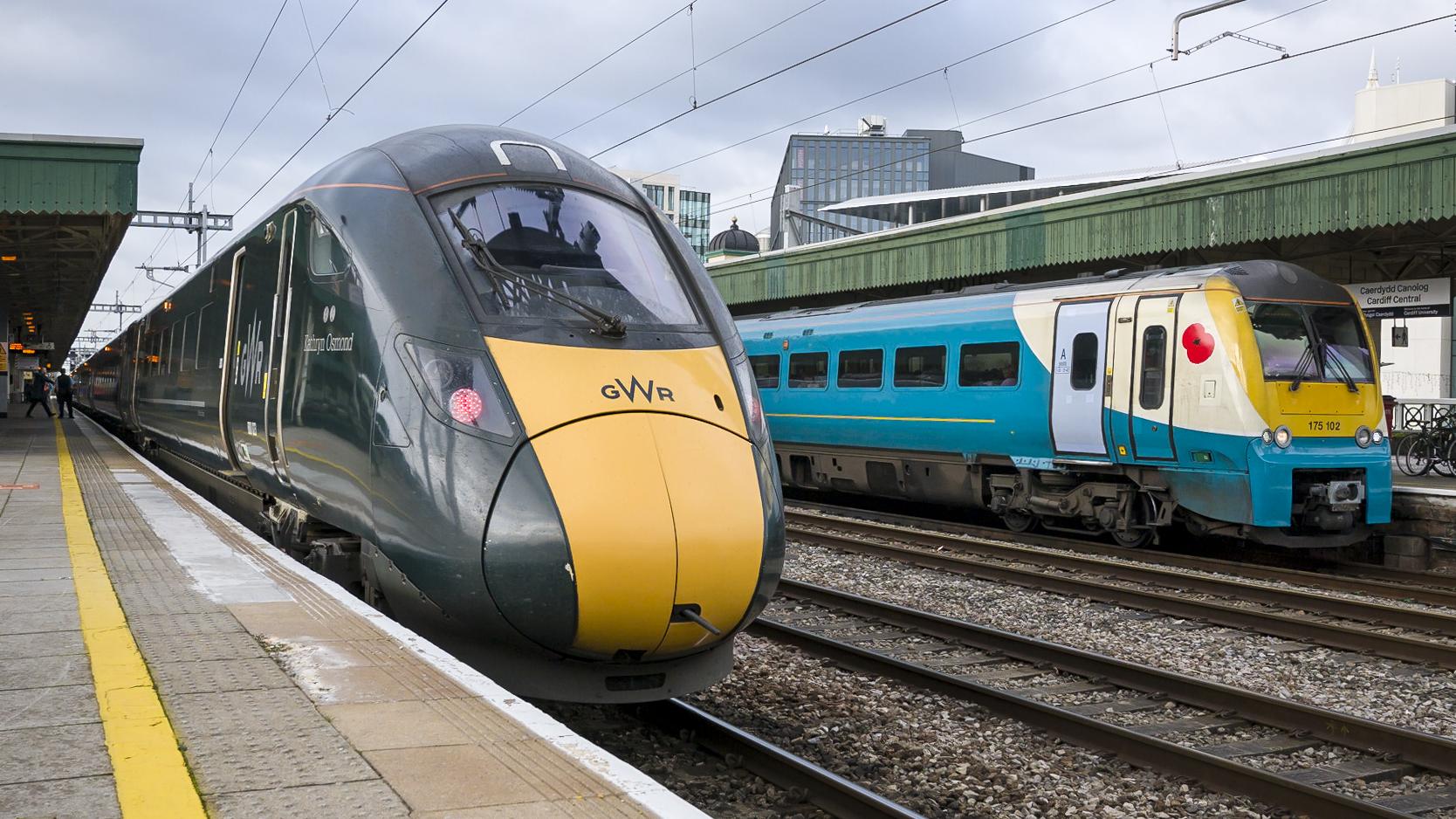 An image of a Great Western Railway and a Transport for Wales train stopped at a station.