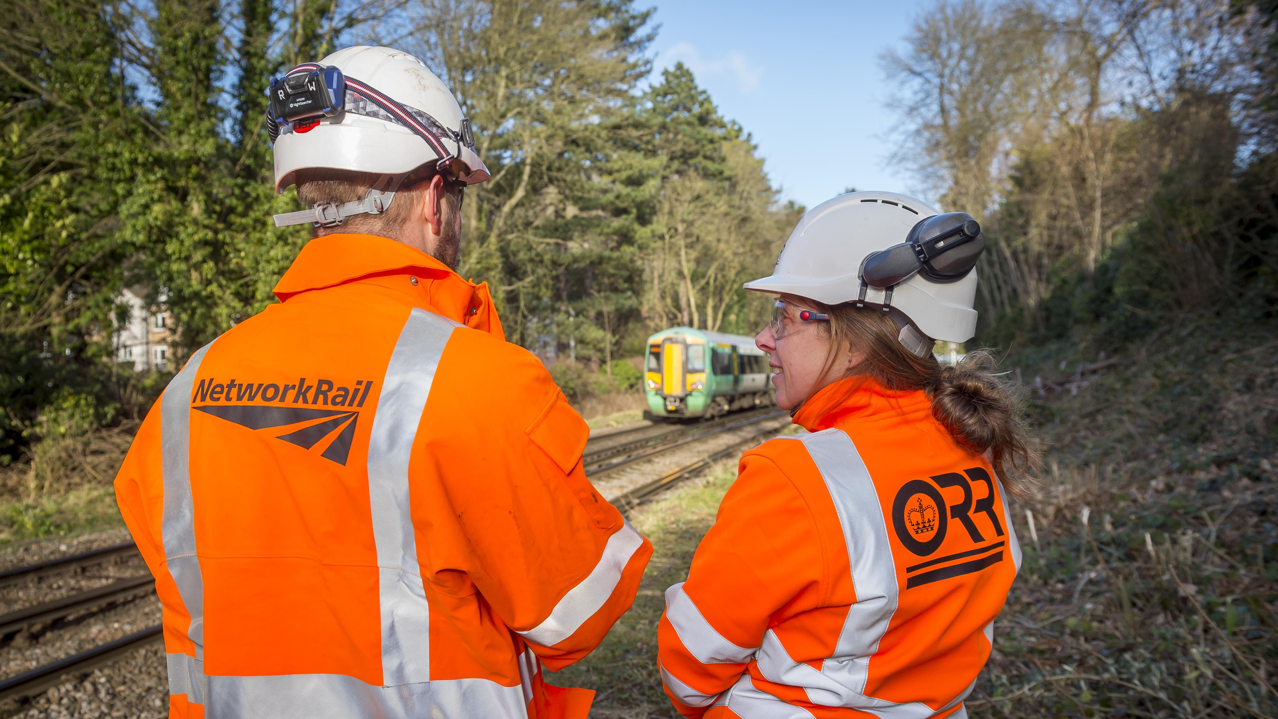 An image of an ORR inspector (right) in discussion with Network Rail (left) on the side of the railway.