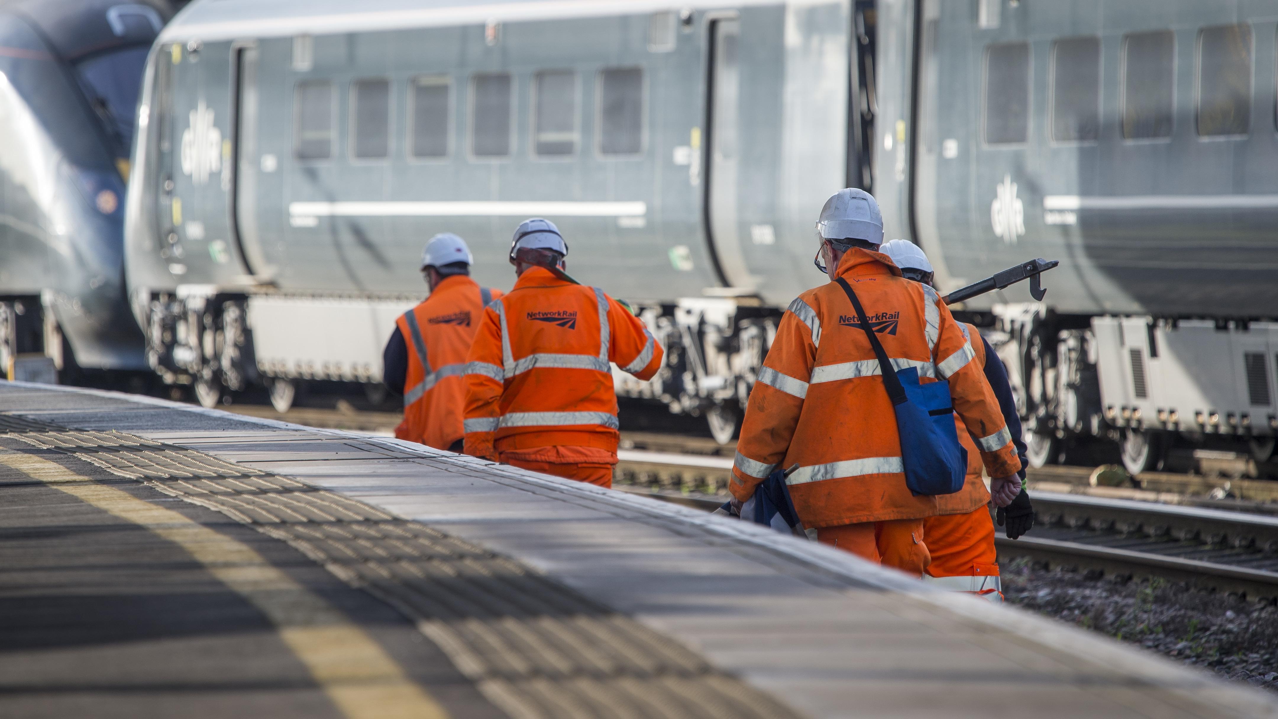An image of four Network Rail workers walking up the railway