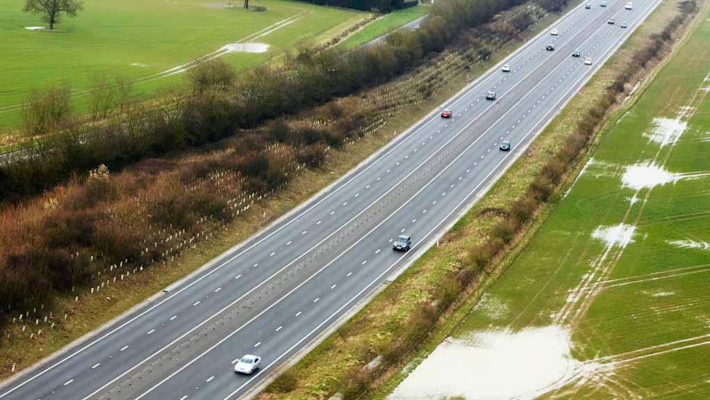 Aerial view of the M11 motorway running through the farmland of Cambridgeshire