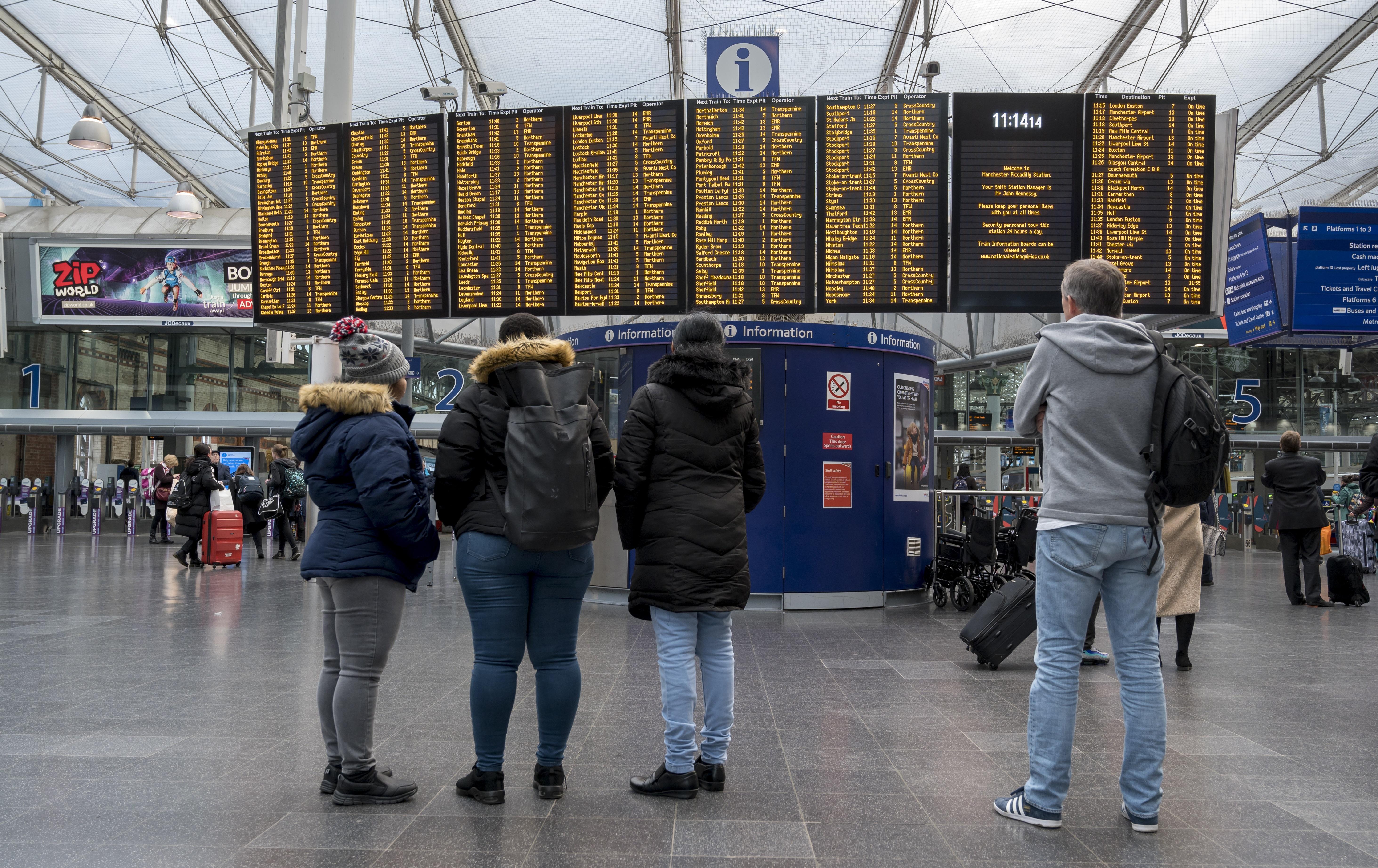 Passengers looking at departure board