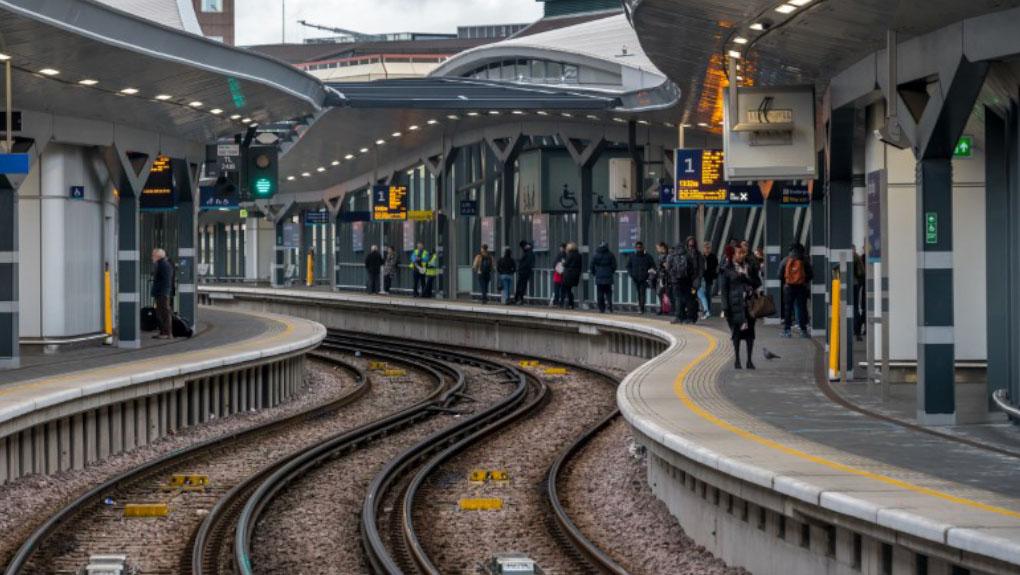 Passengers waiting for the next train at a station platform.