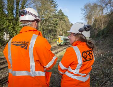 An image of an ORR inspector (right) in discussion with Network Rail (left) on the side of the railway.