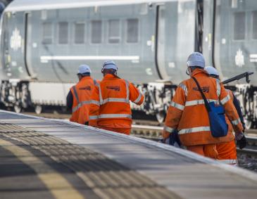 An image of four Network Rail workers walking up the railway