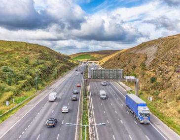 M62 motorway junction 22 looking west towards Rochdale from the Saddleworth Moors Pennine Way Bridge