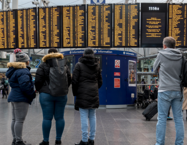 Passengers looking at departure board