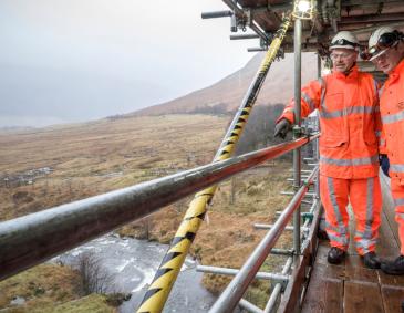 Two O R R inspectors in high visibility clothing and personal protective equipment on a health and safety visit in December 2019 to the Auch Viaduct (UB 310/151) and a nine span, steel railway viaduct near Tyndrum on the West Highland line