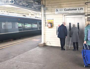 Passengers using a lift at a railway station