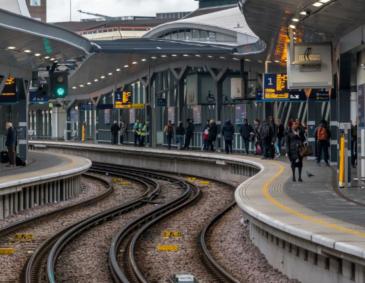 Passengers waiting for the next train at a station platform.