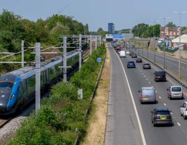 A train on the tracks with cars on the side